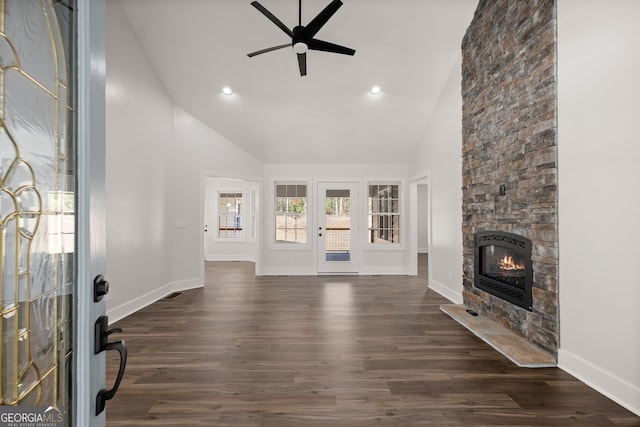 living room featuring ceiling fan, high vaulted ceiling, dark hardwood / wood-style flooring, and a stone fireplace