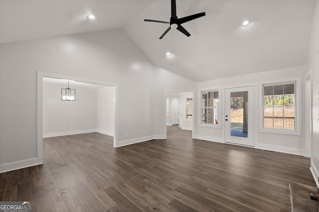 unfurnished living room with high vaulted ceiling, dark hardwood / wood-style flooring, and ceiling fan with notable chandelier