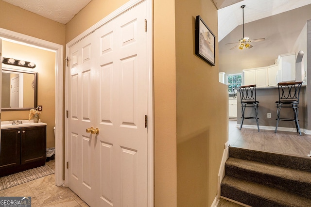 corridor featuring lofted ceiling and sink