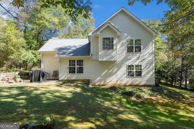 rear view of house featuring a patio area and a lawn