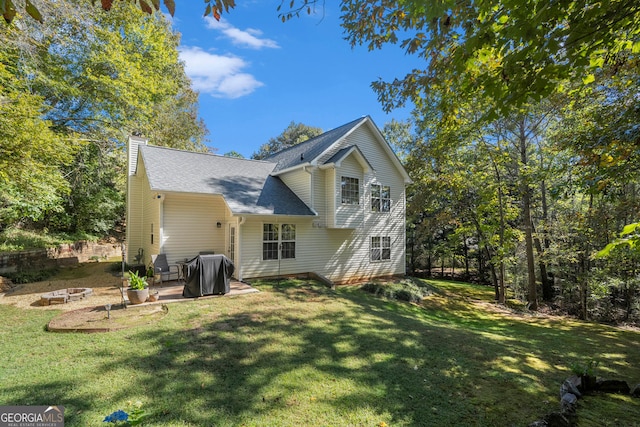 back of house with a yard and a patio