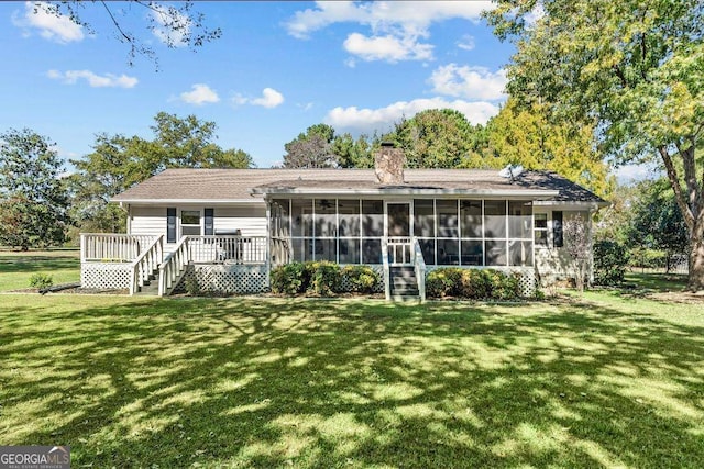 back of house featuring a yard, a sunroom, and a deck