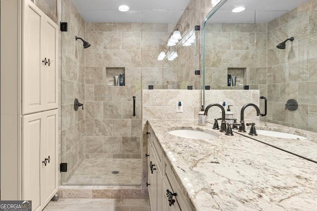 bathroom with tile walls, vanity, and a shower with shower door