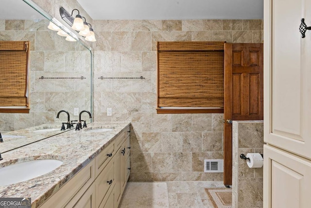 bathroom with vanity and tile walls