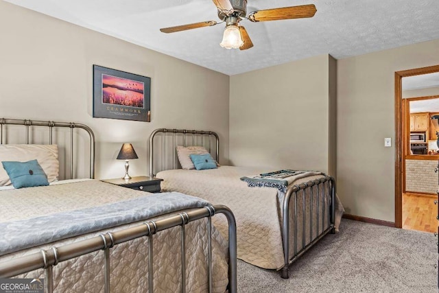 bedroom featuring a textured ceiling, light wood-type flooring, and ceiling fan