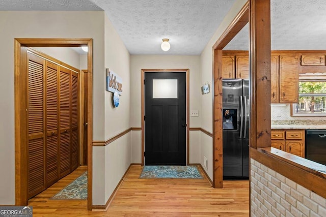 entryway featuring a textured ceiling and light hardwood / wood-style floors