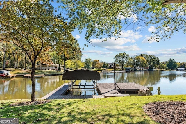 dock area with a water view and a lawn