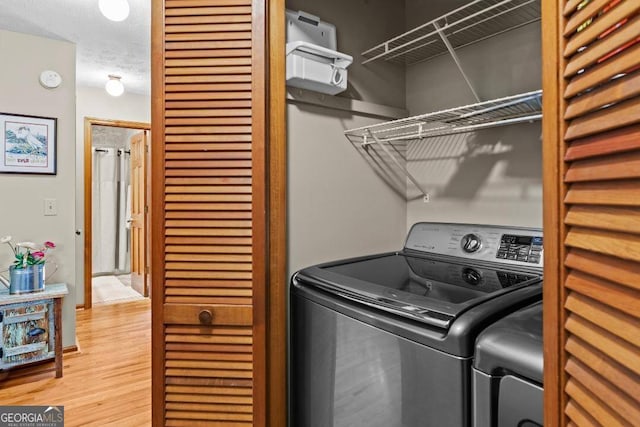 laundry room featuring hardwood / wood-style flooring and a textured ceiling