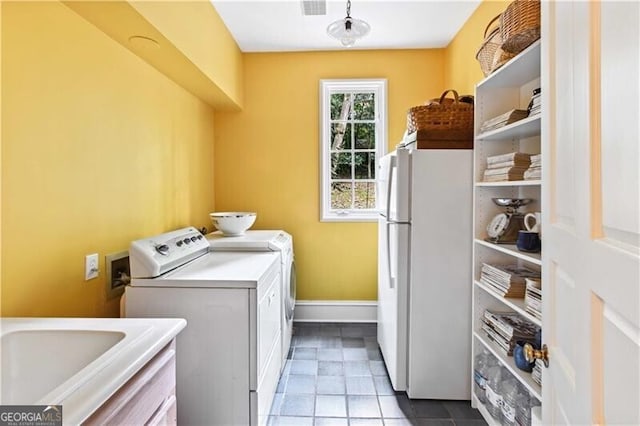 laundry room featuring washing machine and clothes dryer, sink, and light tile patterned floors