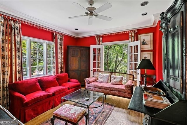 living room with hardwood / wood-style floors, ceiling fan, and crown molding