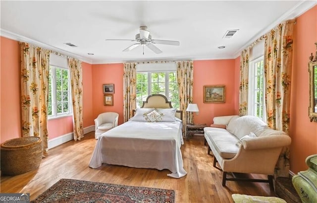 bedroom featuring ceiling fan, light wood-type flooring, and crown molding