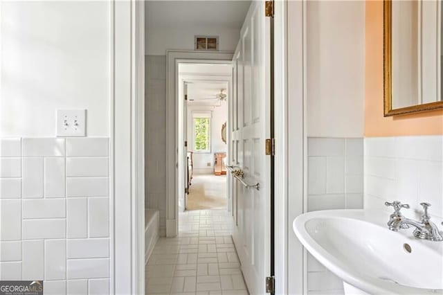 bathroom with tile walls and sink