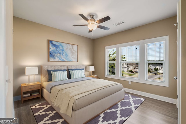 bedroom with dark hardwood / wood-style floors and ceiling fan