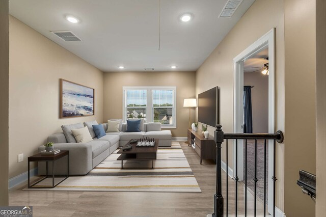 living room with light hardwood / wood-style floors and ceiling fan