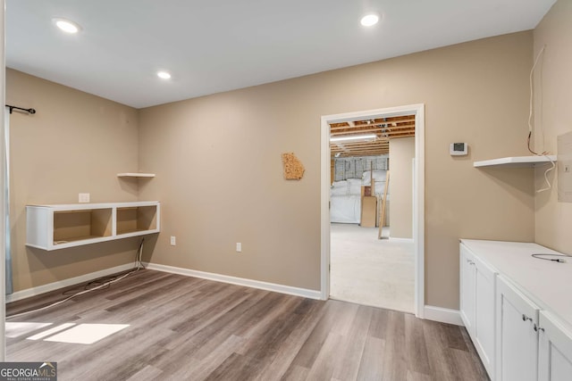 clothes washing area with wood-type flooring