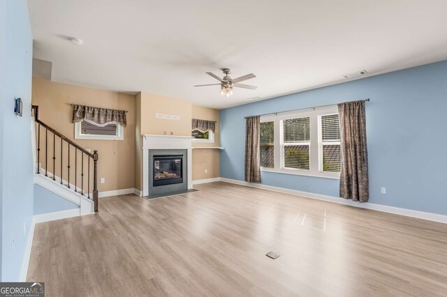 unfurnished living room with light hardwood / wood-style floors and ceiling fan