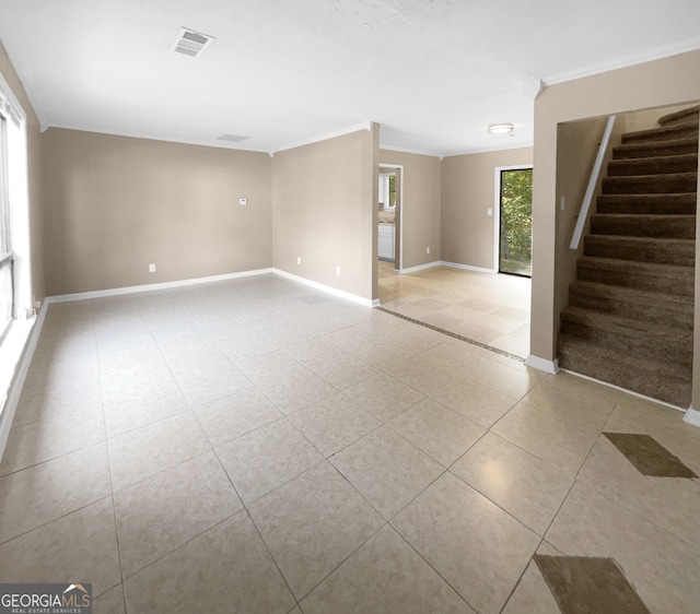 tiled empty room featuring crown molding