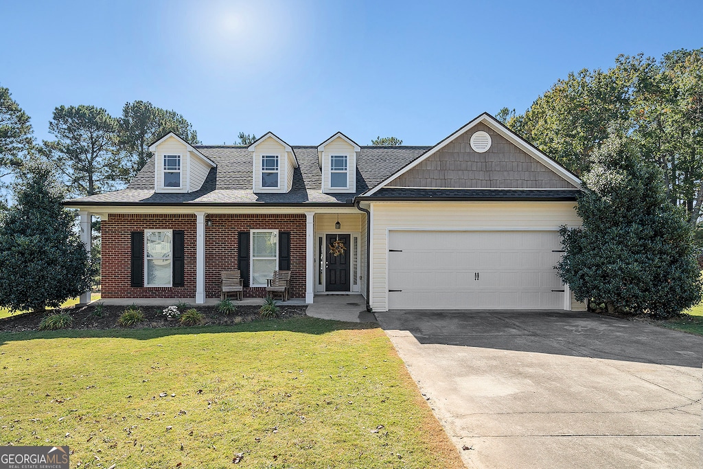 view of front of home with a front yard, a porch, and a garage