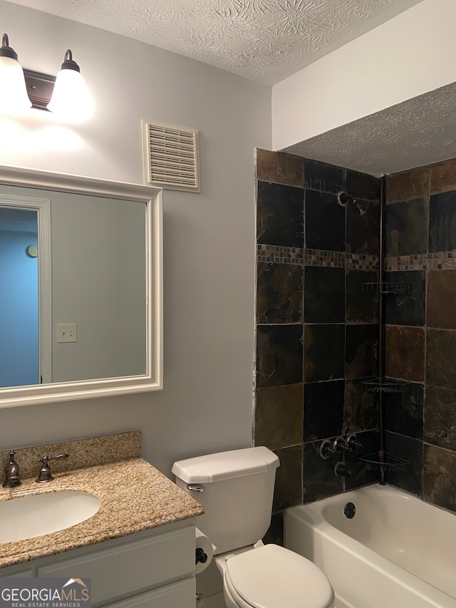 full bathroom with vanity, tiled shower / bath combo, a textured ceiling, and toilet