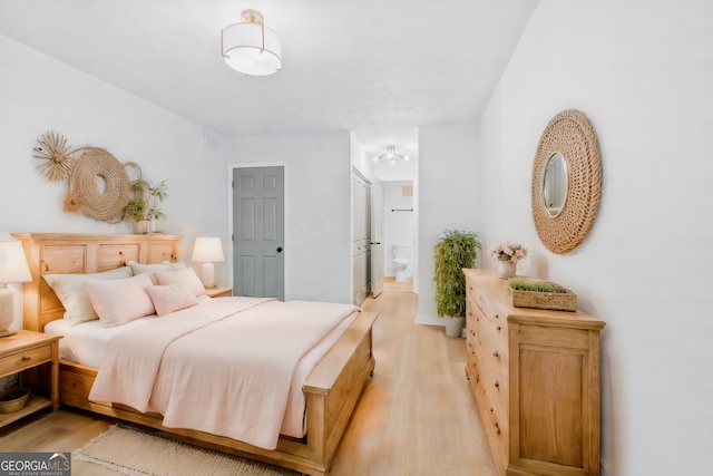 bedroom featuring ensuite bathroom and light hardwood / wood-style floors