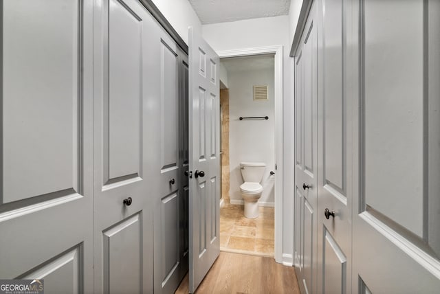 hallway with light hardwood / wood-style floors