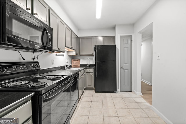 kitchen with gray cabinets, black appliances, sink, and light tile patterned floors