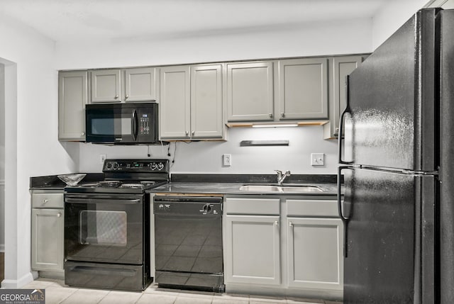 kitchen with light tile patterned floors, black appliances, sink, and gray cabinets