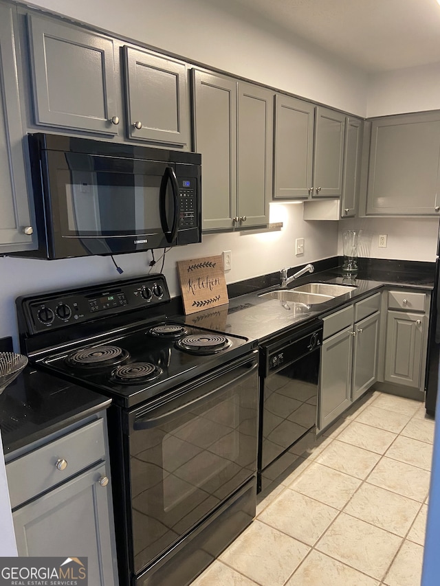 kitchen with sink, black appliances, light tile patterned flooring, and gray cabinetry