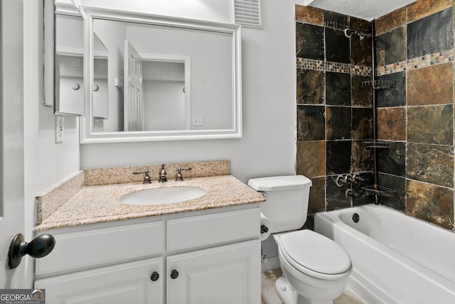 full bathroom with vanity, tiled shower / bath, and toilet