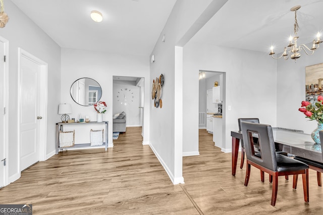 dining space with light hardwood / wood-style flooring and a chandelier