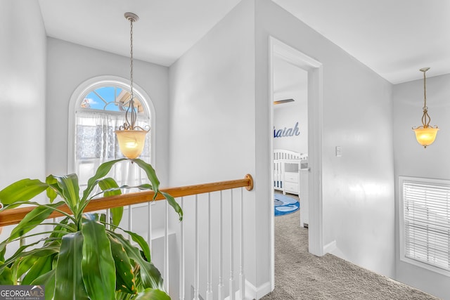 corridor featuring carpet flooring and an inviting chandelier