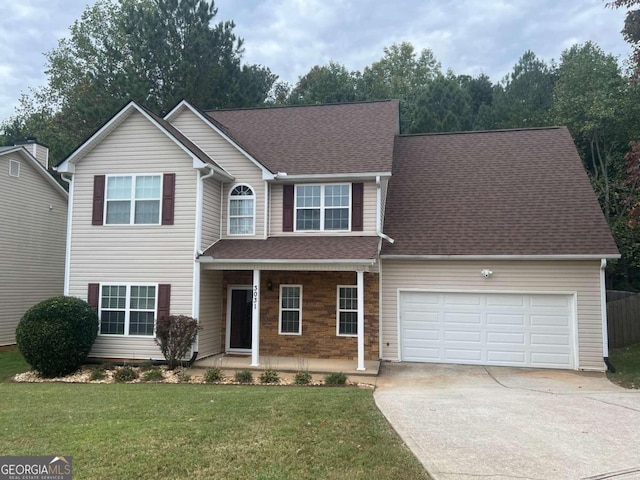 view of property featuring a garage and a front lawn