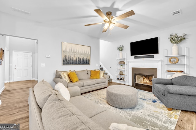 living room with light hardwood / wood-style floors and ceiling fan