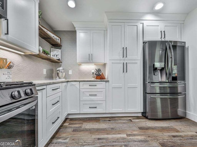 kitchen featuring decorative backsplash, stainless steel fridge with ice dispenser, white cabinetry, light wood-type flooring, and black range oven