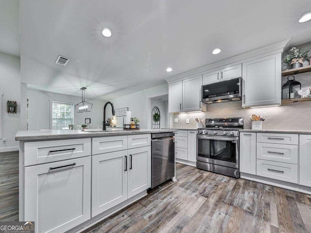 kitchen featuring hanging light fixtures, stainless steel appliances, hardwood / wood-style floors, sink, and white cabinetry