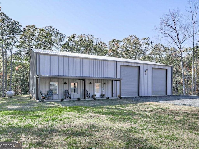 exterior space with a garage, a front lawn, and an outbuilding