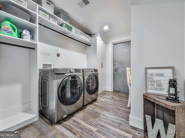 laundry area with washing machine and dryer and wood-type flooring