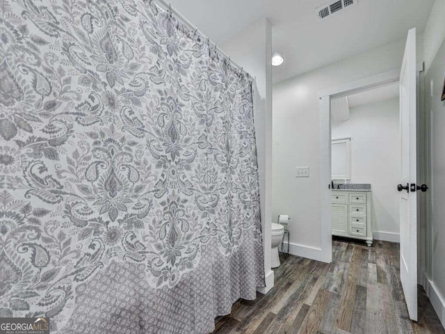 bathroom with vanity, hardwood / wood-style floors, and toilet