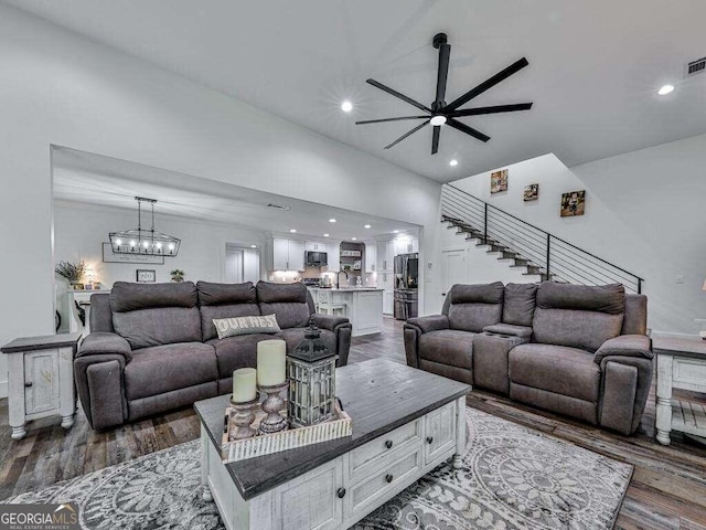 living room with ceiling fan with notable chandelier, sink, and dark hardwood / wood-style floors