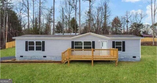 rear view of house featuring a wooden deck and a lawn