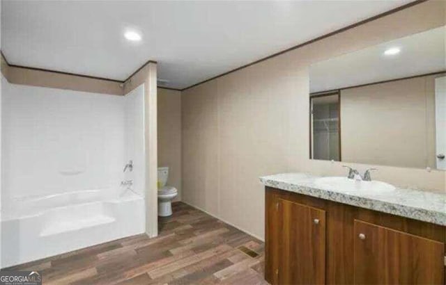 full bathroom with toilet, shower / washtub combination, hardwood / wood-style floors, and vanity