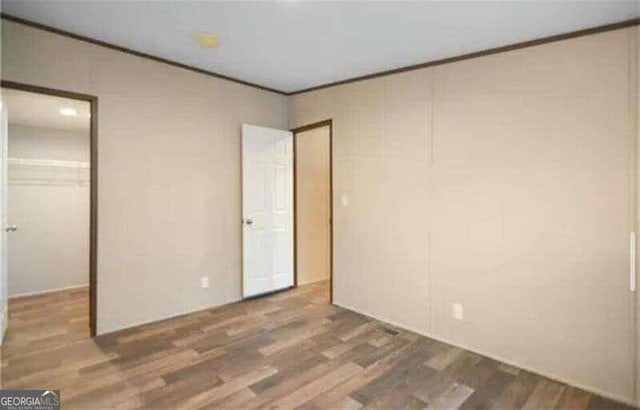 unfurnished bedroom with ornamental molding and dark hardwood / wood-style floors