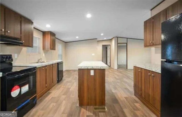 kitchen with black appliances, sink, a kitchen island, extractor fan, and light hardwood / wood-style flooring