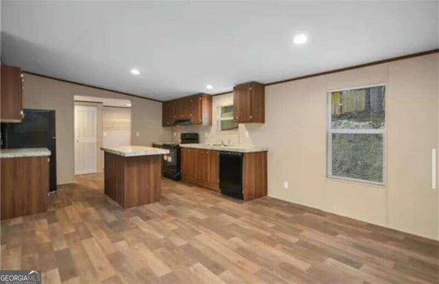 kitchen featuring a center island, hardwood / wood-style flooring, black appliances, and vaulted ceiling