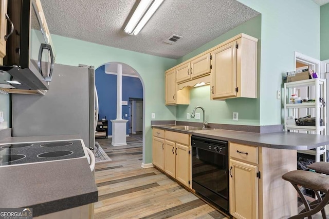 kitchen featuring light hardwood / wood-style floors, dishwasher, a textured ceiling, sink, and a breakfast bar