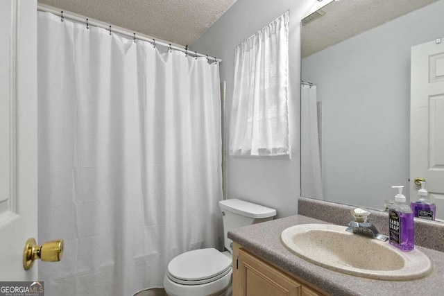 bathroom featuring vanity, toilet, and a textured ceiling