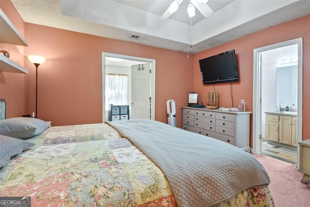 carpeted bedroom with ceiling fan, connected bathroom, and a textured ceiling