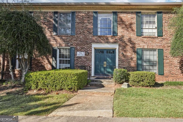 colonial-style house featuring a front lawn