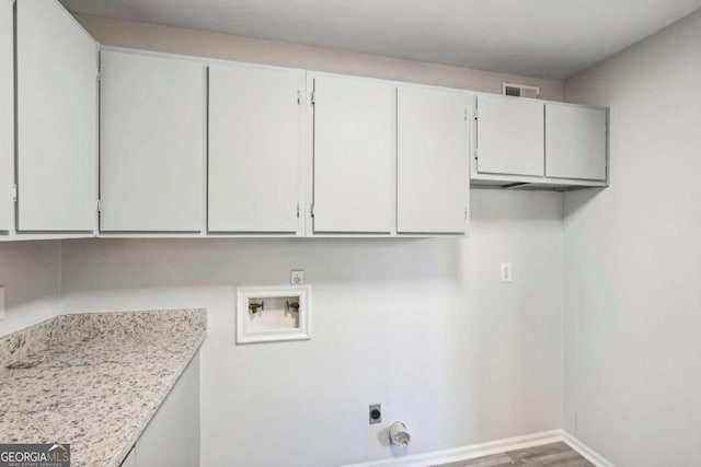 washroom with cabinets, hookup for an electric dryer, hardwood / wood-style flooring, and washer hookup