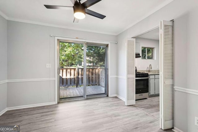 interior space with ornamental molding, light wood-type flooring, and ceiling fan